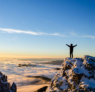 Person on top of a mountain in a victory pose
